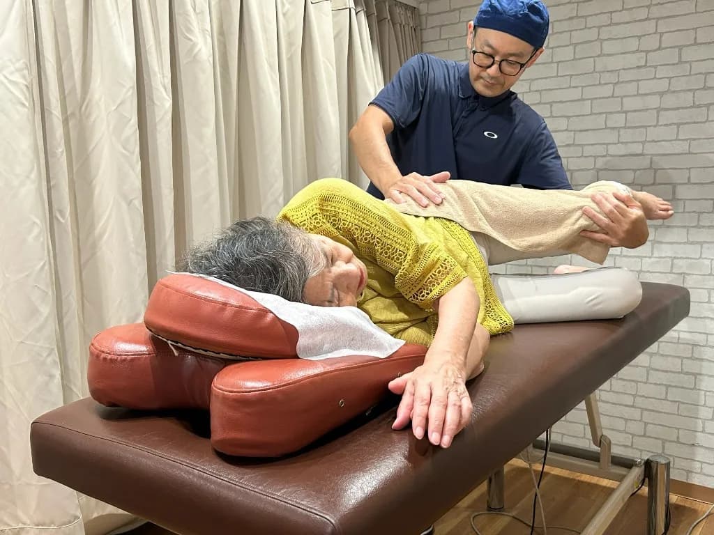施術者が患者の足腰を丁寧にケアしている様子